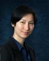 Bio photo of Dr. Teva Hoshizaki smiling with a drak background