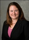 Bio photo of Dr. Nicole Olynk Widmar, smiling in a lavendar shirt under a black suit coat