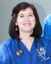 Bio photo of Dr. Jennifer Broadhurst smiling, in blue scubs with a stethoscope