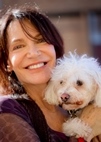 Bio photo of Sherri Franklin smiling and holding a little fluffy white dog