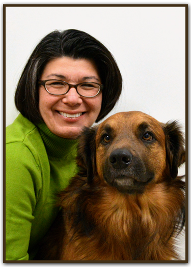 Bio photo of Maria M. Benham smiling next to a large long-haired black and brown dog