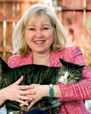 Bio photo of Bonney Brown smiling and holding a mostly black cat