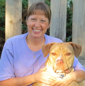 Bio photo of Dr. Brenda Griffin smiling in a lavendar shirt, holding a yellow dog