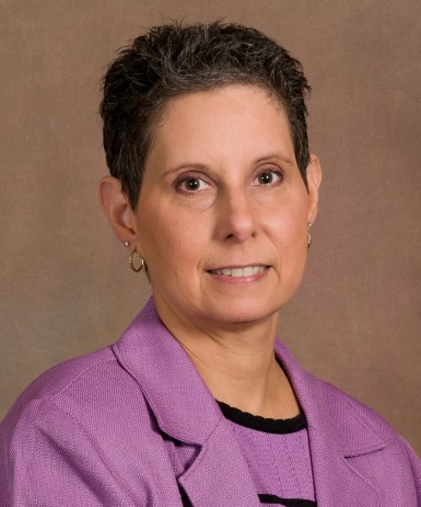 Bio photo of Dr. Karen Moriello smiling in a lavendar suit