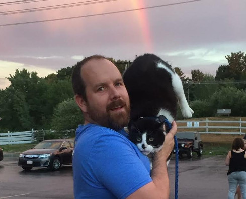 Bio photo of Mike Keiley hilding a back and white cat