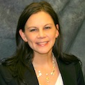Bio photo of Dr. Sara L. Bennett smiling, wearing a dark coat over a white shirt
