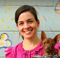 Bio photo of Dr. Ellen Jefferson, smiling in a pink shirt, holding a little brown dog