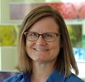 Bio photo of Dr. Julie Levy, smiling in a blue shirt in an indoor setting