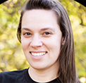 Bio photo of Stephanie Bilbro, smiling in a blue shirt in front of a leafy backgtound