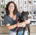 Photo of Lisa Gunter, smiling and holding a black and white dog