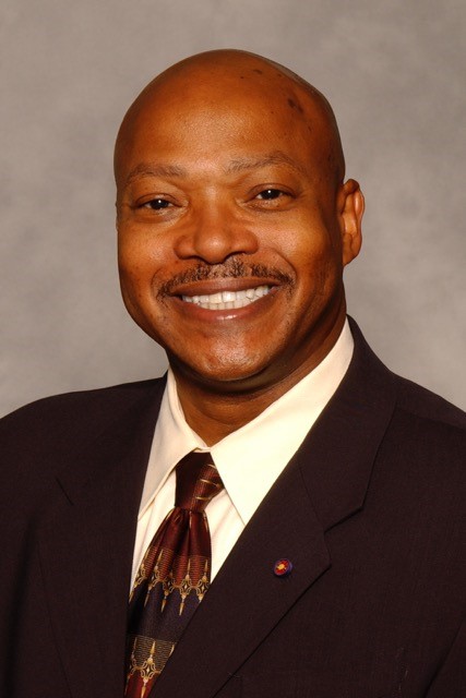 Bio portrait of Dr. Michael Blackwell, smiling in a dark suit and tie