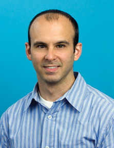 Bio headshot photo of Dr.Brian A. DiGangi, smiling, wearing a blue and white striped shirt