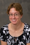 Bio photo of Dr. Elizabeth J. Thomovsky smiling in black and white patterned dress
