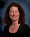 Bio photo of Dr. Elizabeth Berliner wearing a dark shirt and smiling