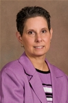 Bio photo of Dr. Karen Moriello smiling in a lavendar suit